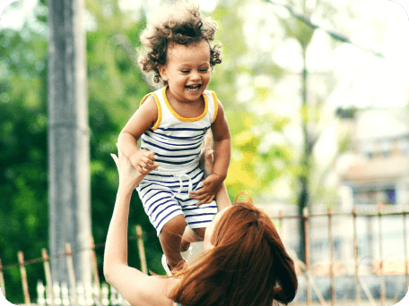 Woman playing with her daughter and throwing her into the air